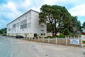un grand bâtiment blanc avec une enseigne devant dans l'établissement Le Nid de Men Er Beleg - Appt proche plage, à Saint-Philibert