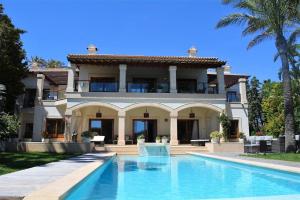 a large house with a swimming pool in front of it at Andratx Villa: A Stylish Oasis of Relaxation, 1043 in Andratx