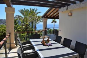 a table on a patio with a view of the ocean at Andratx Villa: A Stylish Oasis of Relaxation, 1043 in Andratx