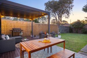 a patio with a wooden table and a grill at The Eighth - Pet Friendly in Rosebud