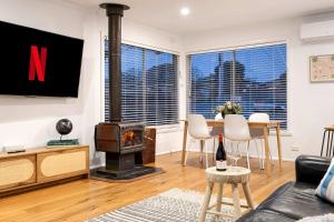 a living room with a wood stove and a table at The Eighth - Pet Friendly in Rosebud