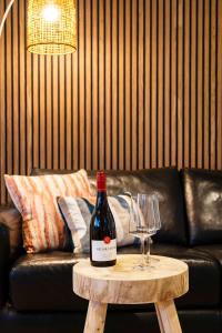 a bottle of wine on a table next to a couch at The Eighth - Pet Friendly in Rosebud