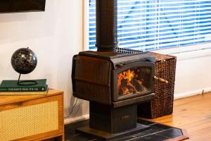 a wood stove sitting in a room next to a window at The Eighth - Pet Friendly in Rosebud +25 photos