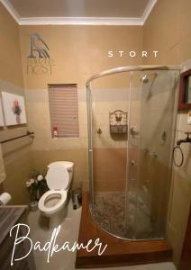 a bathroom with a toilet and a shower at Ravens Nest in Bloemfontein +4 photos
