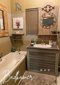 une salle de bain avec une baignoire et un lavabo et une baignoire dans l'établissement Ravens Nest, à Bloemfontein