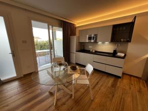 a living room with a glass table and a kitchen at MyCircle Stintino in Stintino