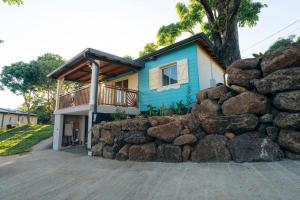 a blue house with a stone wall in front of it at Les Ti Kaz d'Auguste in Les Avirons +89 photos