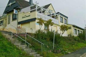 a building on a hill with stairs in front of it at The Great View Sauna & more in Harscheid