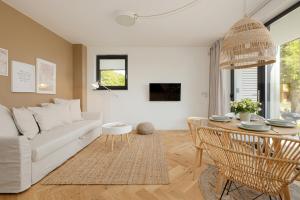 a living room with a white couch and a table at LoveSea apartments Rewal in Rewal