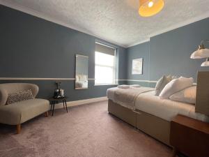 a bedroom with a bed and a chair and a window at Wedgwood Hotel - Room 6 in Llandudno