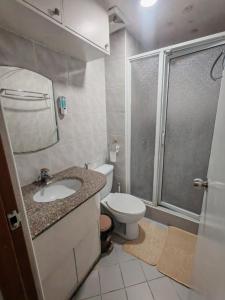 Un baño con inodoro, lavabo y ducha. en Cozy Condo in Baguio, en Baguio 13 fotos más