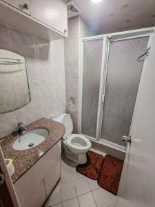 Un baño con ducha, inodoro y lavabo. en Cozy Condo in Baguio, en Baguio