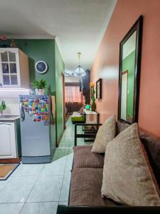 Una sala de estar con un sofá y un refrigerador. en Cozy Condo in Baguio, en Baguio