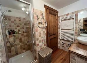 un bagno con doccia e lavandino di La casetta del cuore tra terme e montagna a Pré-Saint-Didier Altre 13 foto