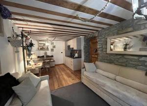 a living room with a couch and a stone wall at La casetta del cuore tra terme e montagna in Pré-Saint-Didier