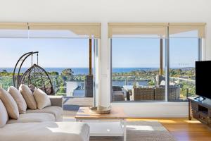 Una sala de estar con un sofá y una ventana grande. en Family Holiday Retreat - Pool & Bay Views, en Mount Martha