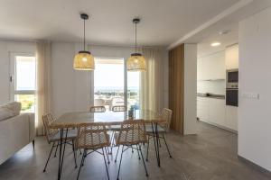 une cuisine et une salle à manger avec une table et des chaises dans l'établissement AT Ponent V, à La Playa de la Torre de Piles