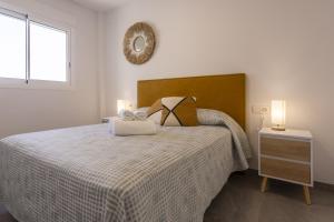 une chambre avec un lit et un miroir au mur dans l'établissement AT Ponent V, à La Playa de la Torre de Piles 10 autres photos