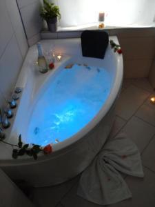a bath tub filled with blue water in a bathroom at Modern Flat in Radolfzell am Bodensee