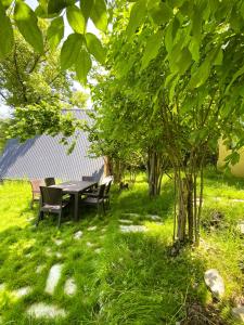 a table and chairs in a yard with trees at Wonderwood Borjomi Provencal in Borjomi