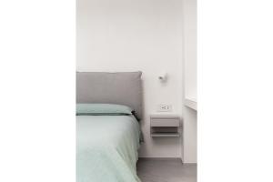a white bedroom with a bed and a night stand at Via dei Monti in Nesso