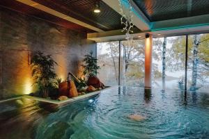 a swimming pool in a house with a large window at Hotel Haikko Manor & Spa in Porvoo