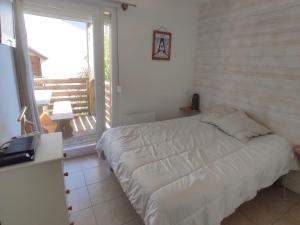 a white bed in a room with a window at Sylvestre - Aux pieds des pistes vue sur lac in Les Angles