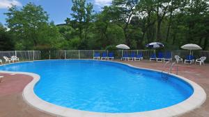 a large swimming pool with chairs and umbrellas at VVF Les Gorges de l'Allier in Lavoûte-Chilhac