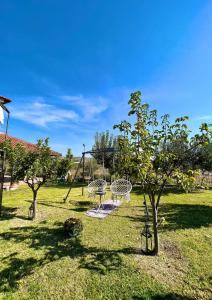 a park with two swings and trees in the grass at Artistic Escape in Vasilikí