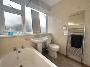 a bathroom with a tub and a toilet and a sink at 3bed house Brighouse - working professionals welcome FREE parking & WI-FI in Brighouse +40 photos
