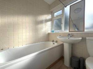 a bathroom with a white tub and a sink and a bath tub at 3-Bed House Brighouse Parking Wi-Fi Near M62 in Brighouse +55 photos
