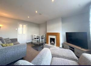a living room with two couches and a tv at 3bed house Brighouse - working professionals welcome FREE parking & WI-FI in Brighouse