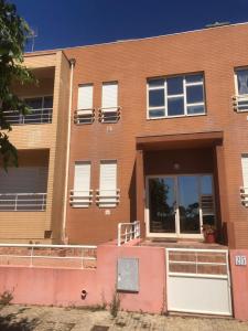 a brown brick building with white doors and windows at Brisa do Mar Vila Chã in Vila Chã +1 photo