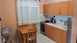 een kleine keuken met een tafel en een wastafel bij Paulos Apartment in Pefkochori