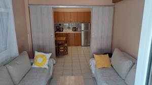 een woonkamer met twee banken en een keuken bij Paulos Apartment in Pefkochori