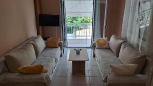 een woonkamer met een bank en een tafel bij Paulos Apartment in Pefkochori