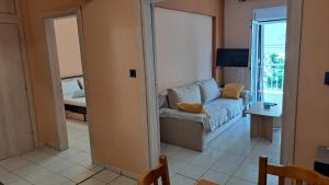 een woonkamer met een bank en een tafel bij Paulos Apartment in Pefkochori +1 foto