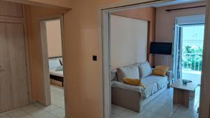 een woonkamer met een bank en een glazen schuifdeur bij Paulos Apartment in Pefkochori