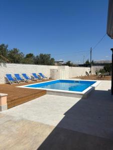 a swimming pool with lounge chairs next to at Villa Gioia in Villaggio Peruzzo