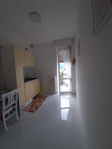 a white room with a kitchen with a door open at Luino Flowers Home in Luino