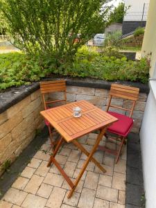 - une table en bois et 2 chaises sur la terrasse dans l'établissement 40qm Wohlfühl-Apartment im Grünen mit Sorglospaket, à Wuppertal