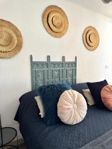 a bedroom with a bed with pillows and hats on the wall at Studio , gîte 1, confortable et calme au millieu des vignes in Moussan +16 photos