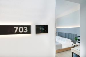 a bedroom with a bed and a tv on a wall at Icon Central SKG in Thessaloniki