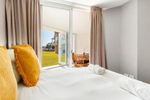 a bedroom with a bed and a large window at Lagoon Beach 29A by Host Agents in Cape Town +32 photos