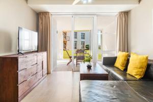 a living room with a couch and a television at Lagoon Beach 29A by Host Agents in Cape Town
