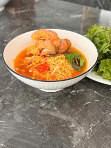 a bowl of soup with shrimp and noodles on a table at Apec Mandala Mui Ne by LHG - Sea View, Infinity Pool, Alacarte, 17m to Bàu Trắng Bình Thuận in Mui Ne +44 photos