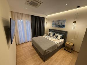 a bedroom with a bed and a tv in it at Azure Ionian in Agios Georgios