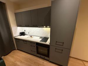 a kitchen with black cabinets and a sink at Azure Ionian in Agios Georgios