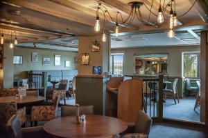 a restaurant with tables and chairs and a bar at The Throckmorton in Alcester