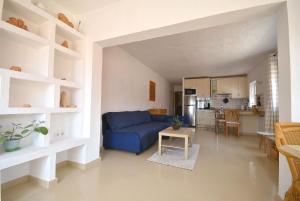Una sala de estar con un sofá azul y una cocina. en Dharma Home, en Costa Calma